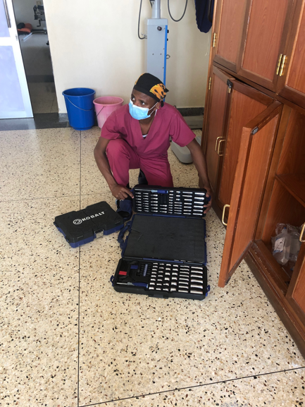 Dr-Kisitu-breaking-out-the-hardware-tools-Uganda-Spine-Surgery-Mission-2019-Day8